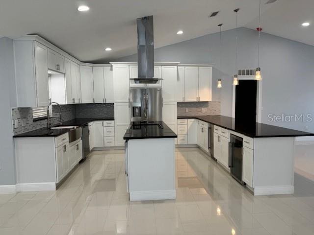 kitchen featuring tasteful backsplash, hanging light fixtures, white cabinetry, stainless steel appliances, and exhaust hood