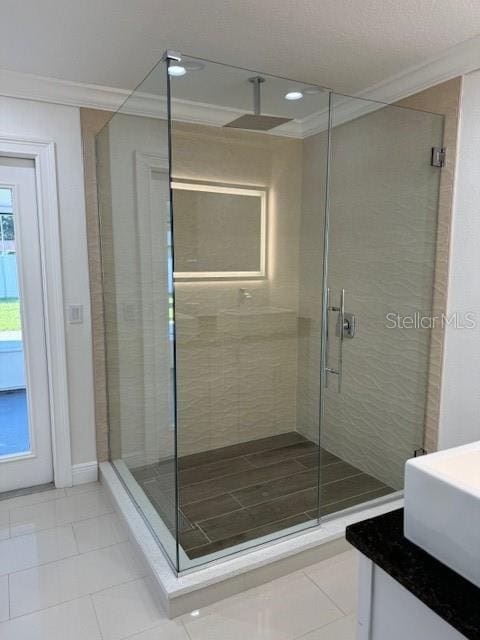 bathroom with vanity, crown molding, tile patterned flooring, and a shower with door