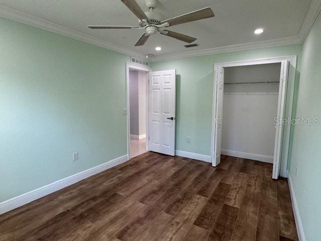 unfurnished bedroom featuring dark wood-type flooring, ceiling fan, a closet, and ornamental molding