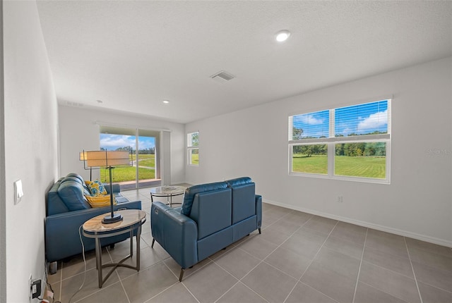 living room featuring light tile patterned flooring and a textured ceiling