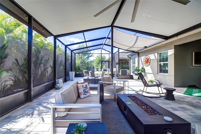 view of patio / terrace with glass enclosure and an outdoor living space with a fire pit