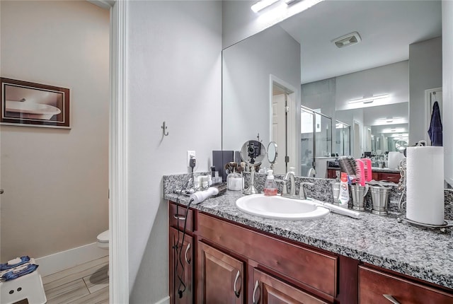 bathroom featuring vanity, toilet, and an enclosed shower