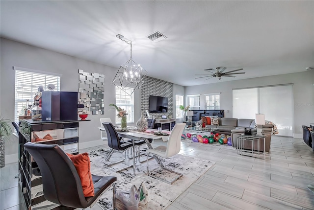 dining room featuring ceiling fan with notable chandelier and plenty of natural light