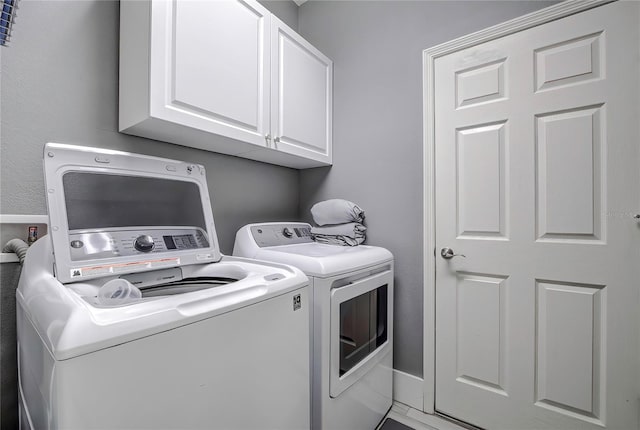 laundry room with cabinets and separate washer and dryer