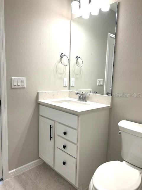 bathroom with vanity, toilet, and tile patterned floors