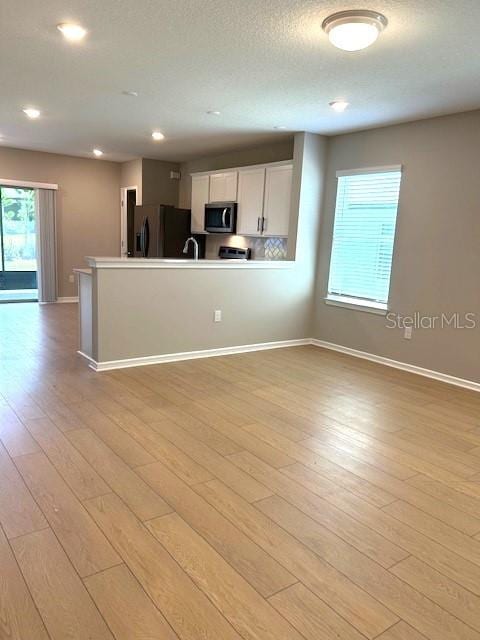 kitchen featuring white cabinets, light hardwood / wood-style floors, and refrigerator with ice dispenser