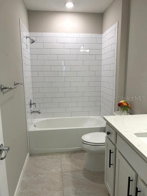 full bathroom featuring tile patterned flooring, tiled shower / bath combo, vanity, and toilet