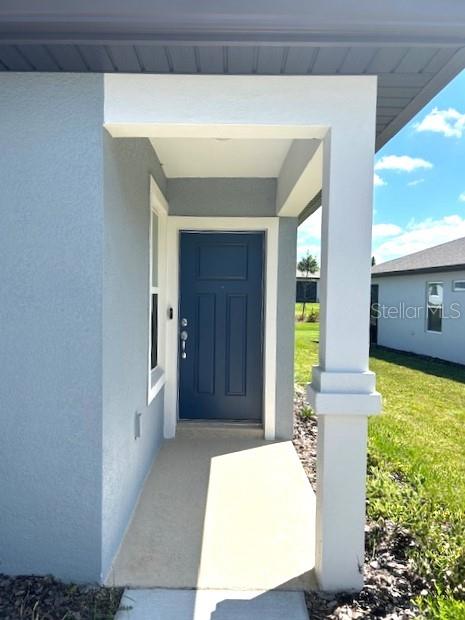 view of exterior entry featuring a yard