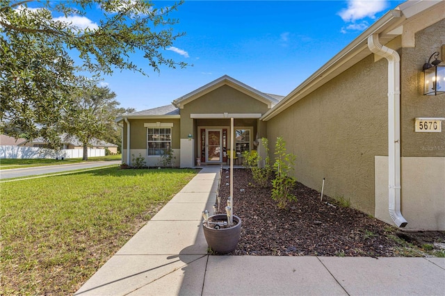 entrance to property featuring a lawn