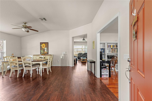 dining room featuring a textured ceiling, vaulted ceiling, dark wood-type flooring, and ceiling fan