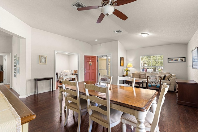 dining area featuring a textured ceiling, lofted ceiling, dark wood-type flooring, and ceiling fan