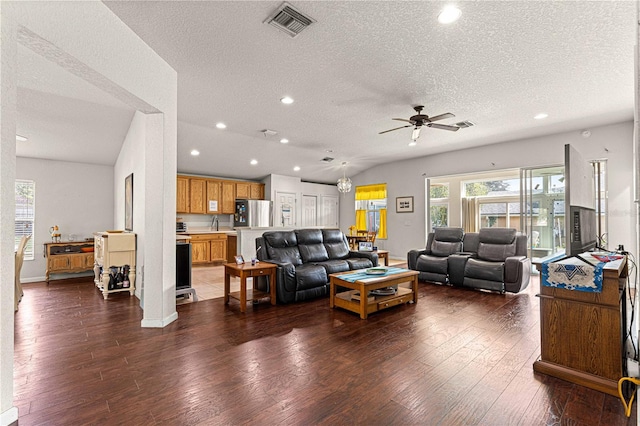 living room featuring a textured ceiling, ceiling fan, sink, and dark hardwood / wood-style flooring