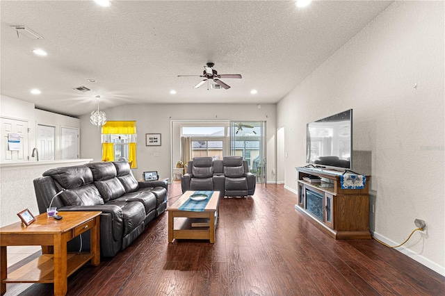 living room featuring a textured ceiling, ceiling fan with notable chandelier, and dark hardwood / wood-style flooring