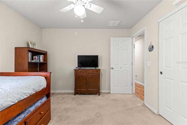 bedroom featuring ceiling fan, light colored carpet, and a textured ceiling