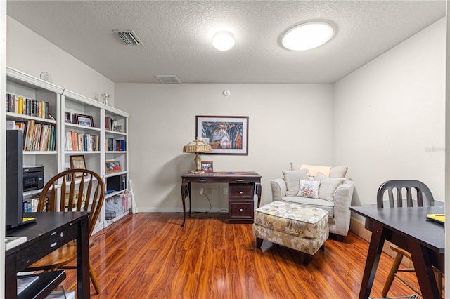 sitting room with a textured ceiling and dark hardwood / wood-style floors