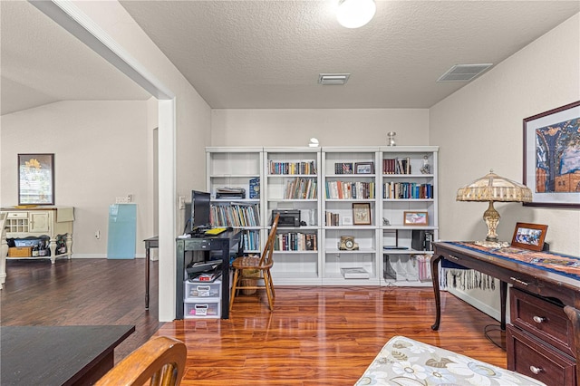 office space with vaulted ceiling, a textured ceiling, and hardwood / wood-style floors