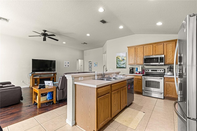 kitchen featuring light hardwood / wood-style floors, sink, stainless steel appliances, a center island with sink, and ceiling fan