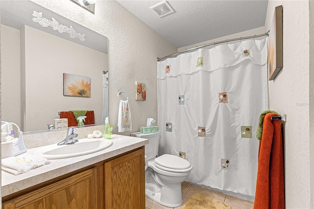 bathroom with tile patterned flooring, a textured ceiling, vanity, and toilet