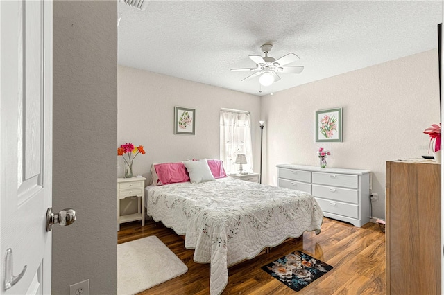 bedroom with ceiling fan, a textured ceiling, and hardwood / wood-style floors