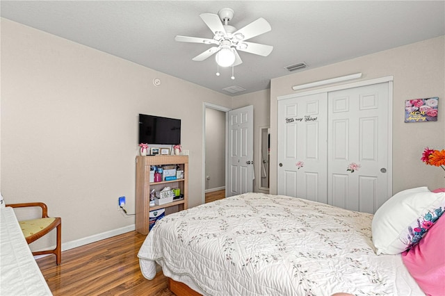 bedroom featuring a closet, dark hardwood / wood-style floors, and ceiling fan