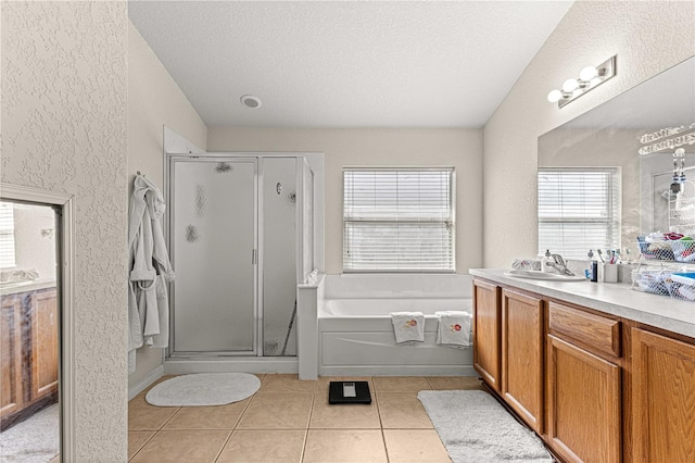 bathroom featuring a textured ceiling, lofted ceiling, tile patterned floors, separate shower and tub, and vanity