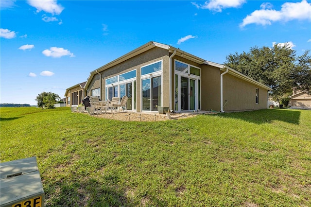 back of house featuring a lawn and a patio area