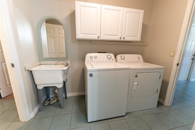 laundry room featuring cabinets, washer and dryer, and light tile patterned flooring