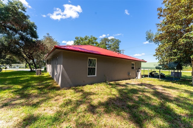 rear view of house featuring cooling unit, a yard, and a carport