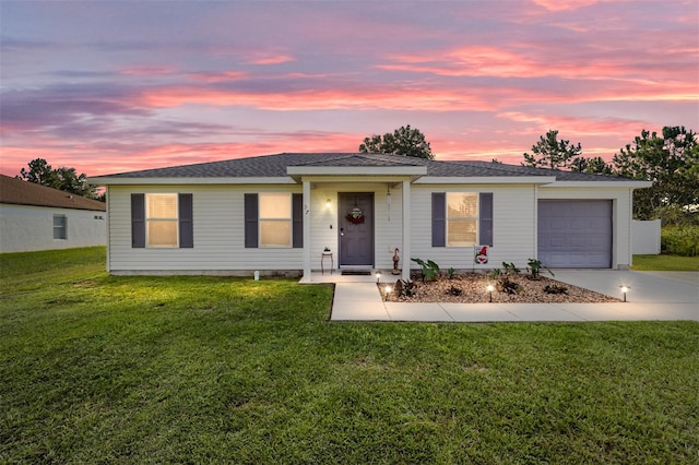 ranch-style house with a garage and a yard