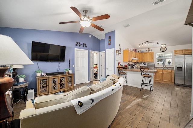 living room featuring wood-type flooring, sink, vaulted ceiling, and ceiling fan