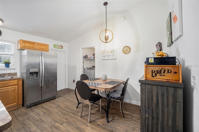 dining area featuring sink, lofted ceiling, dark wood-type flooring, and washer and dryer