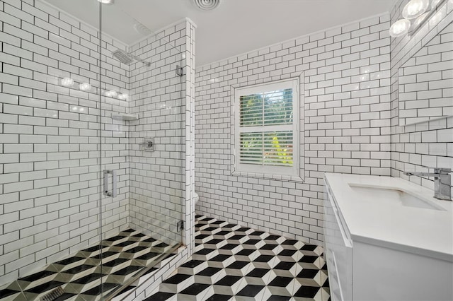 full bathroom featuring a stall shower, toilet, vanity, and tile walls