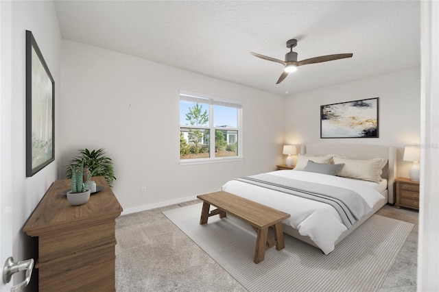 carpeted bedroom with ceiling fan and a textured ceiling