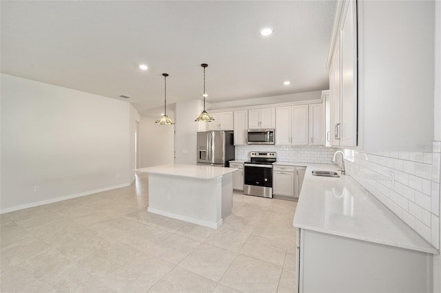 kitchen featuring white cabinetry, sink, hanging light fixtures, a kitchen island, and appliances with stainless steel finishes