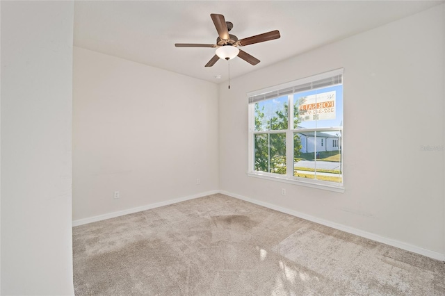 spare room with ceiling fan and light colored carpet