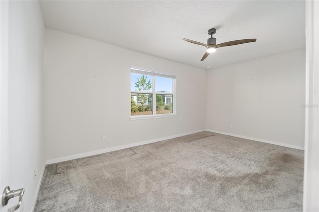 empty room featuring a textured ceiling, light colored carpet, and ceiling fan