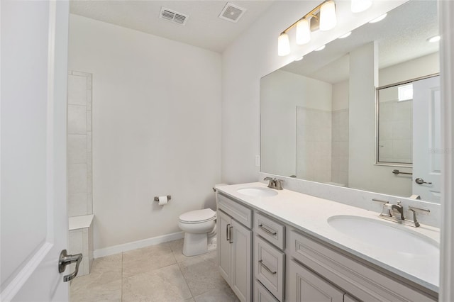 bathroom with tile patterned floors, walk in shower, a textured ceiling, vanity, and toilet