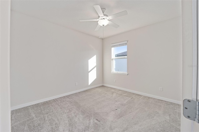 spare room with light colored carpet and ceiling fan