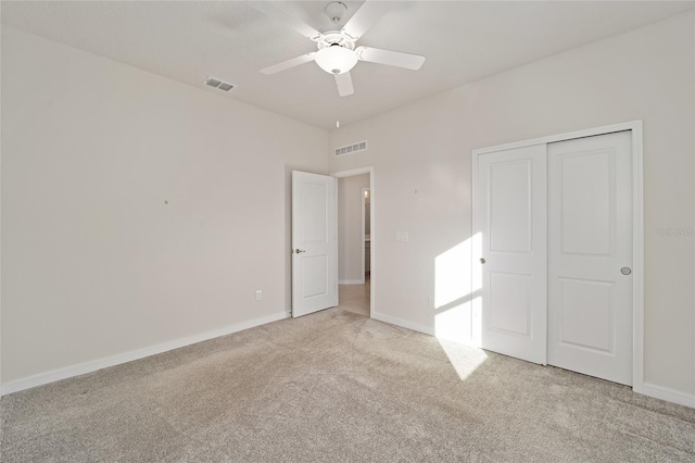 unfurnished bedroom with light carpet, a closet, and ceiling fan