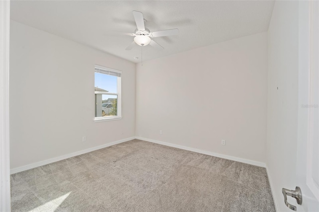 spare room with ceiling fan and light colored carpet