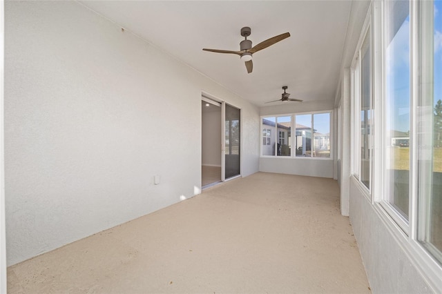 unfurnished sunroom with ceiling fan