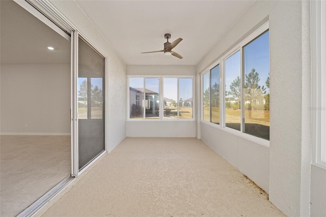 unfurnished sunroom with ceiling fan