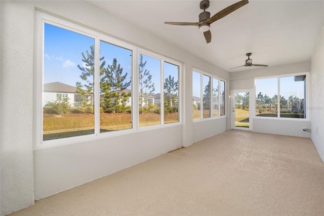 unfurnished sunroom featuring ceiling fan