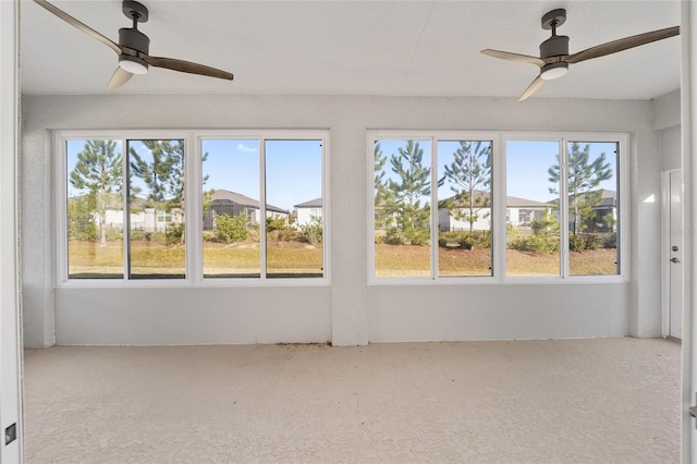 unfurnished sunroom featuring a wealth of natural light and ceiling fan