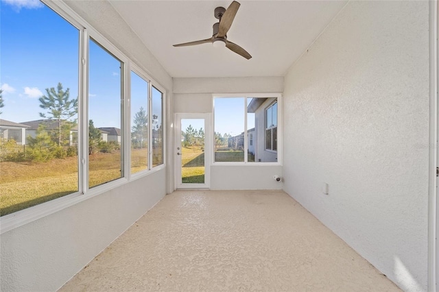 unfurnished sunroom with ceiling fan