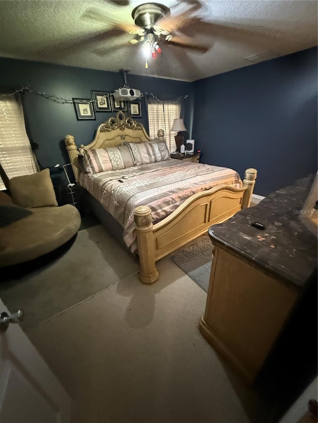 carpeted bedroom with ceiling fan and a textured ceiling