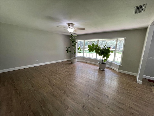 empty room with ceiling fan and dark wood-type flooring