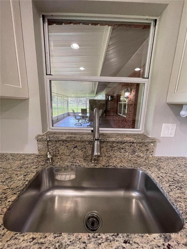 9526 SW 72nd Ct, Ocala, FL 34476 - kitchen view of a sink, white cabinets, and light stone countertops