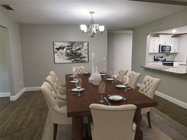 dining room with dark hardwood / wood-style floors and an inviting chandelier