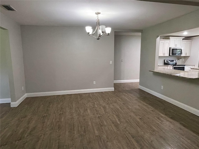 interior space with a notable chandelier and dark hardwood / wood-style flooring